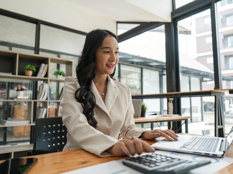 Accountant woman working with calculator and laptop computer, Tax deduction planning concept